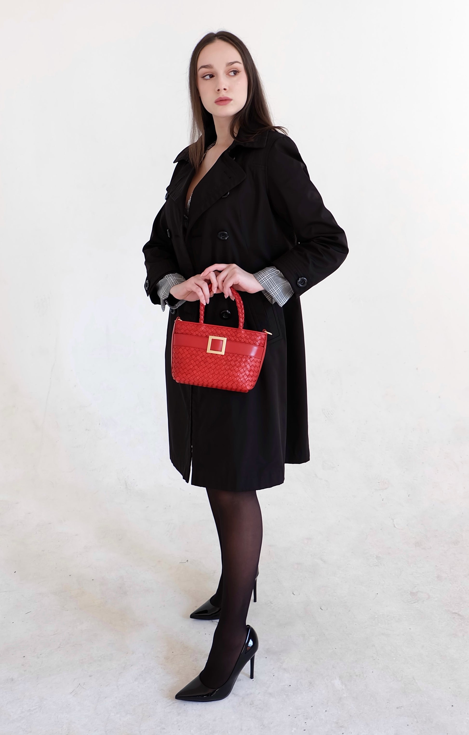 Beautiful, strong, independent, empowered and chic woman wearing a sustainable Italian leather designer handbag, mini tote and crossbody in chili red. Handbag with accent buckle that is a functional work of art.