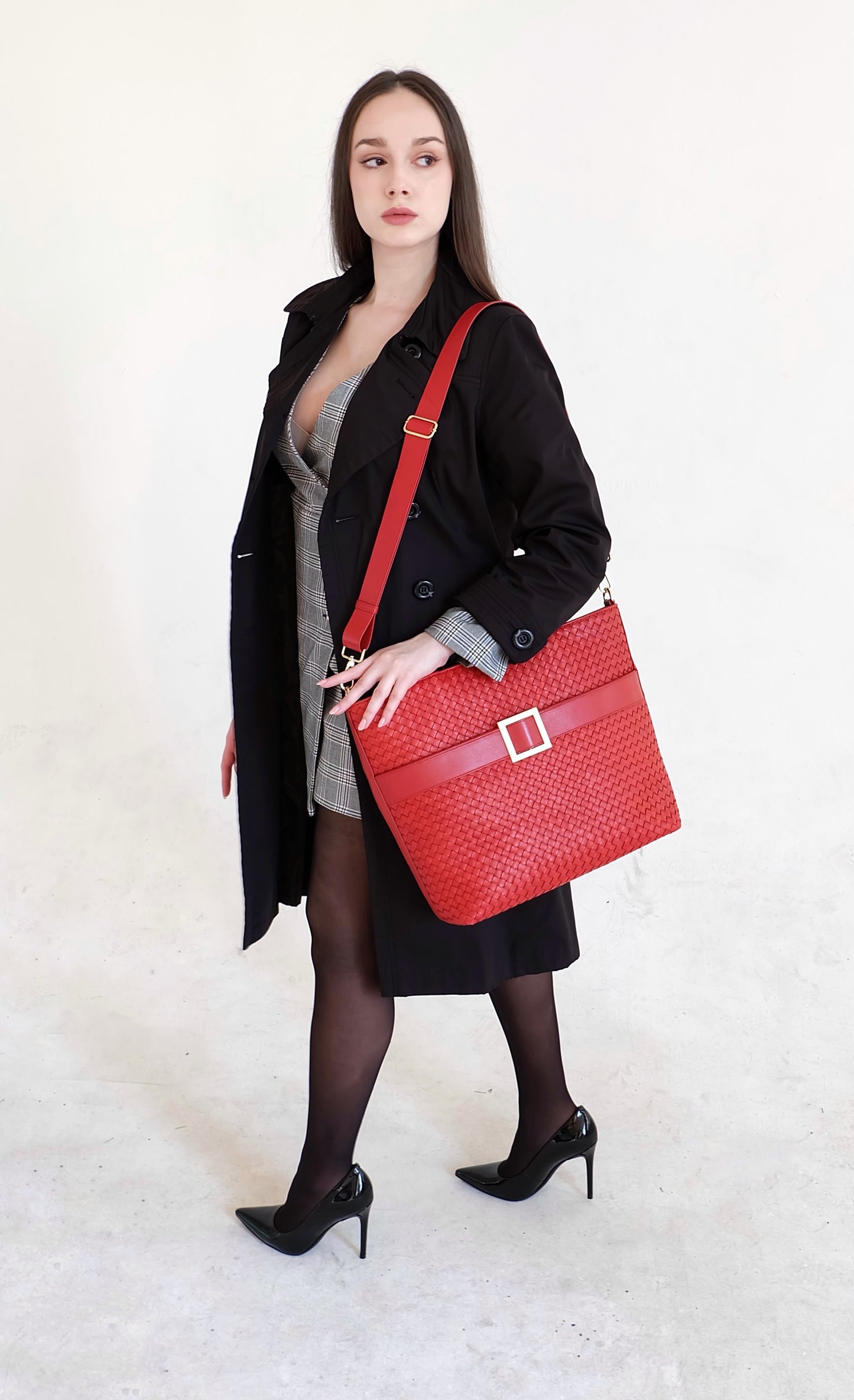 Beautiful, strong, independent, empowered and chic woman wearing a sustainable Italian leather designer handbag, medium tote and crossbody in chili red. Handbag with accent buckle that is a functional work of art.