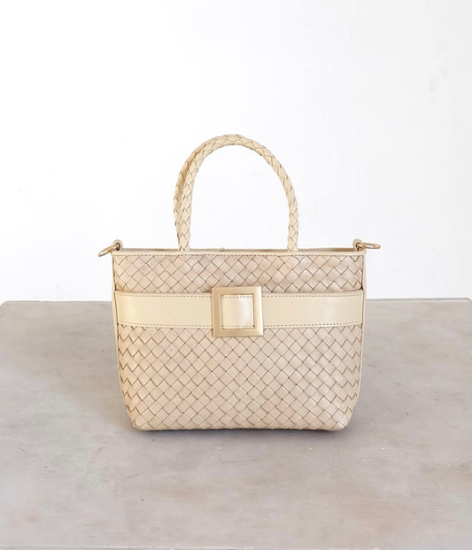 Sustainable Italian leather designer handbag in cream. Braided mini tote bag and crossbody in one, with accent buckle and front compartment.