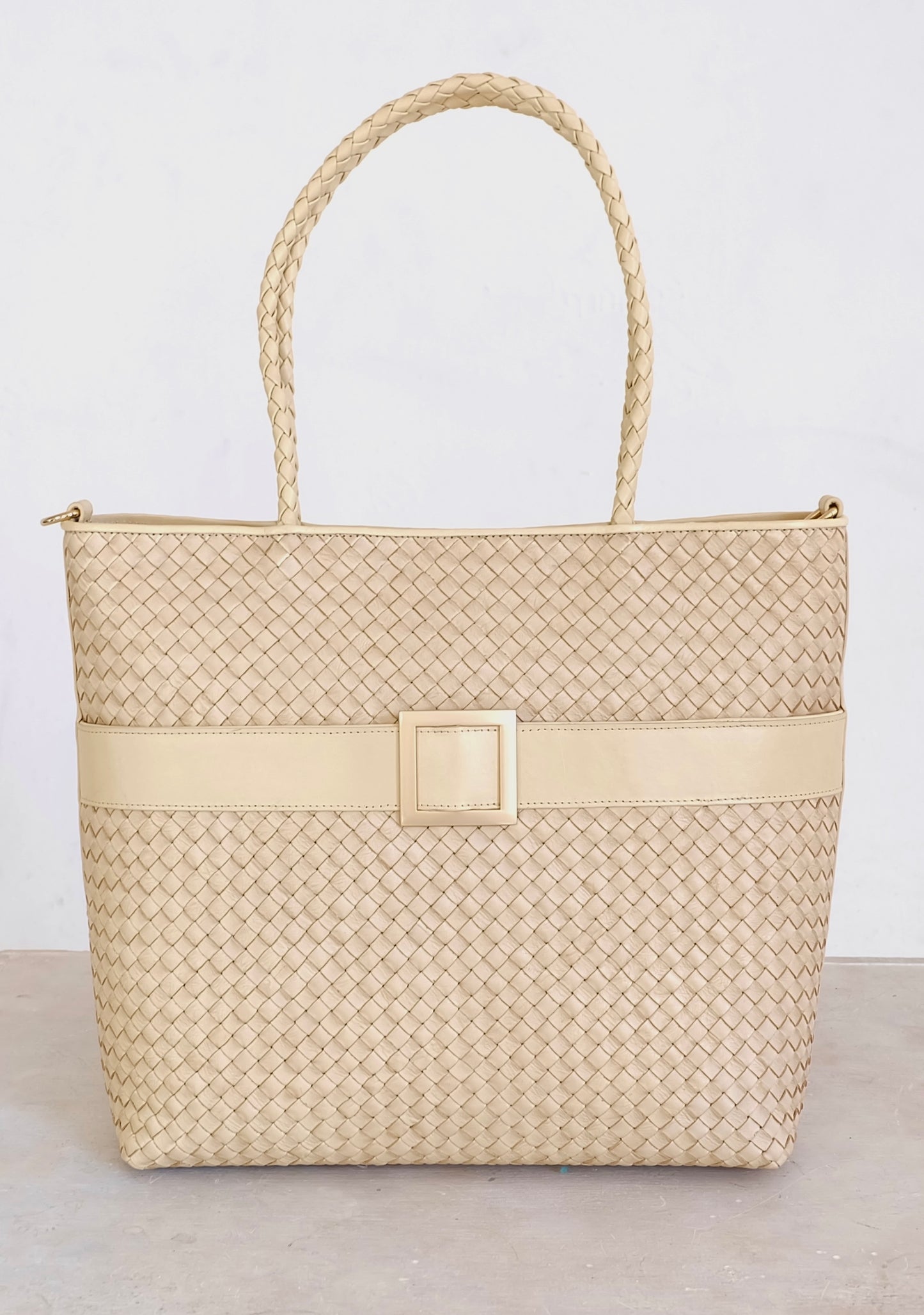 Sustainable Italian leather designer handbag, medium tote and crossbody in cream. Handbag with accent buckle that is a functional work of art.