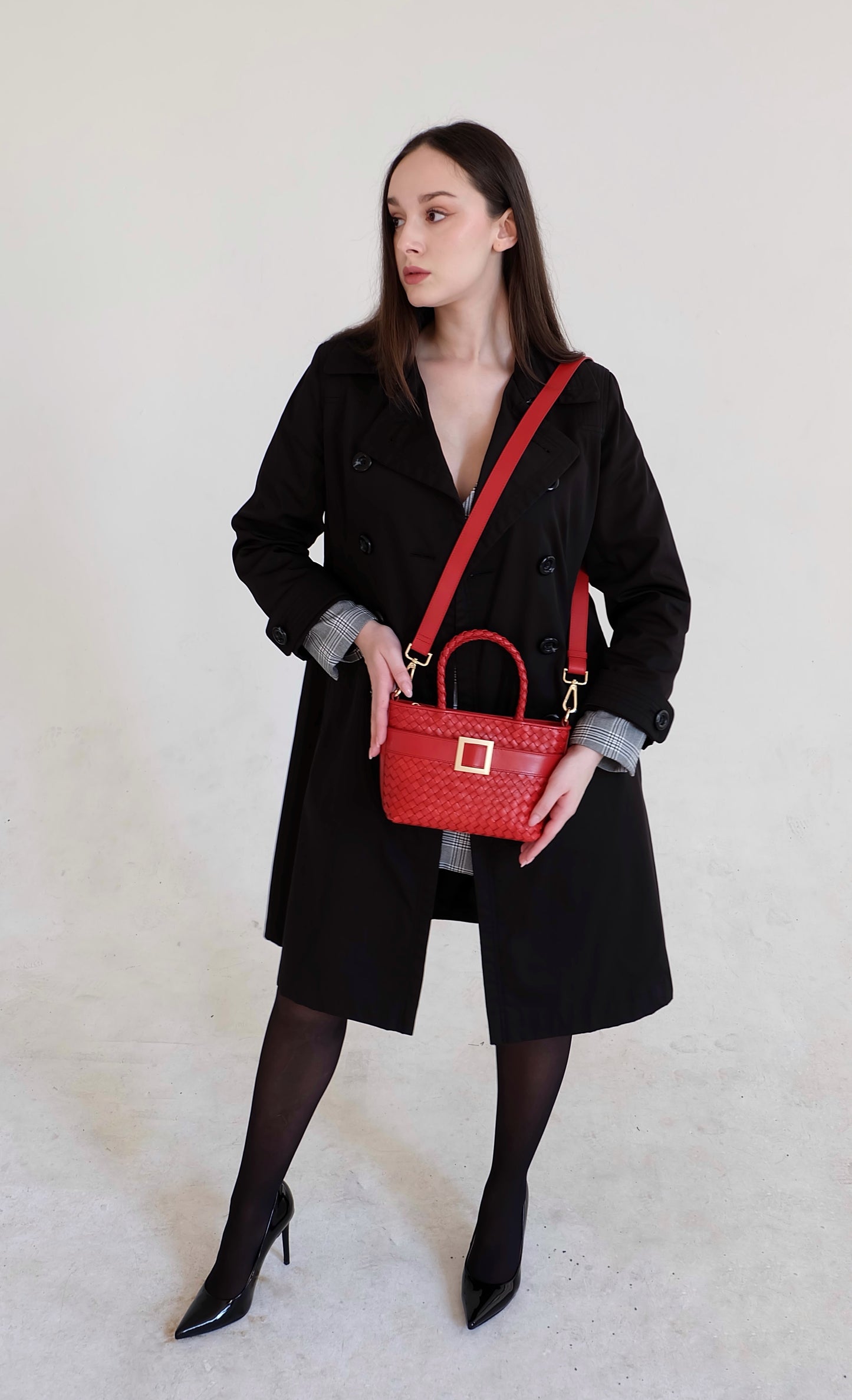 Beautiful, strong, independent, empowered and chic woman wearing a sustainable Italian leather designer handbag, mini tote and crossbody in chili red. Handbag with accent buckle that is a functional work of art.