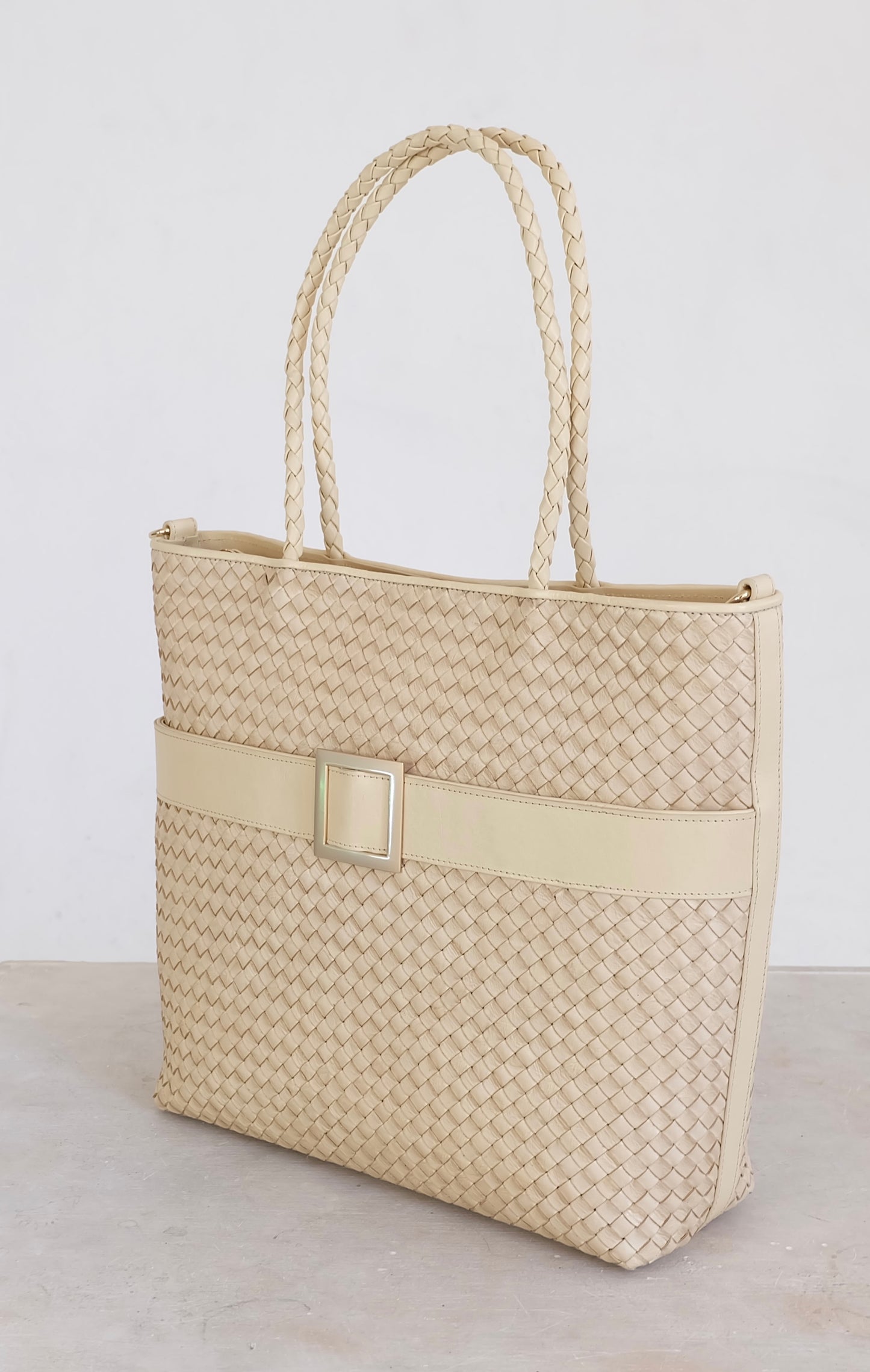 Sustainable Italian leather designer handbag, medium tote and crossbody in cream. Handbag with accent buckle that is a functional work of art.