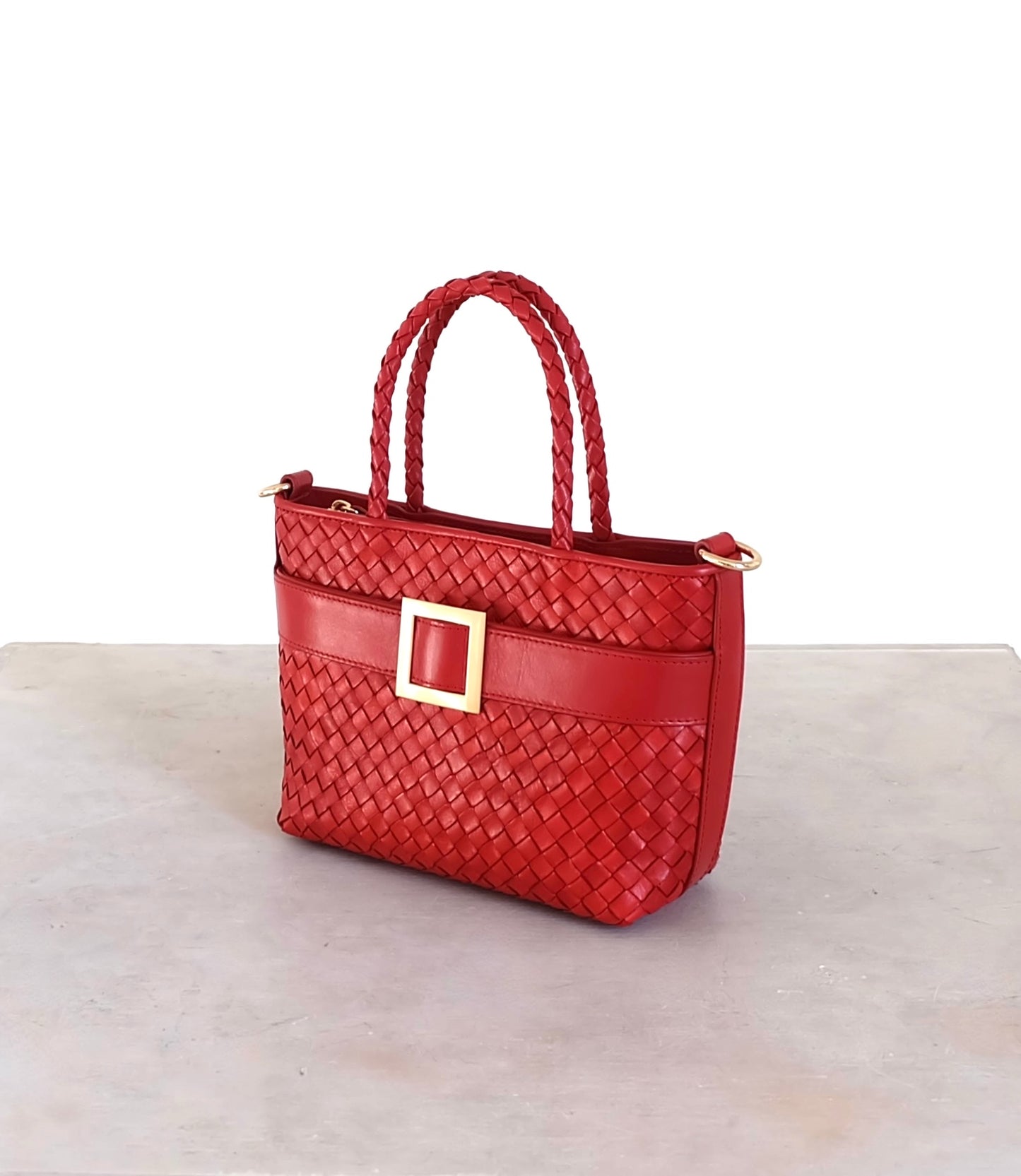 Sustainable Italian leather designer handbag in chili red. Braided mini tote bag and crossbody in one, with accent buckle and front compartment.