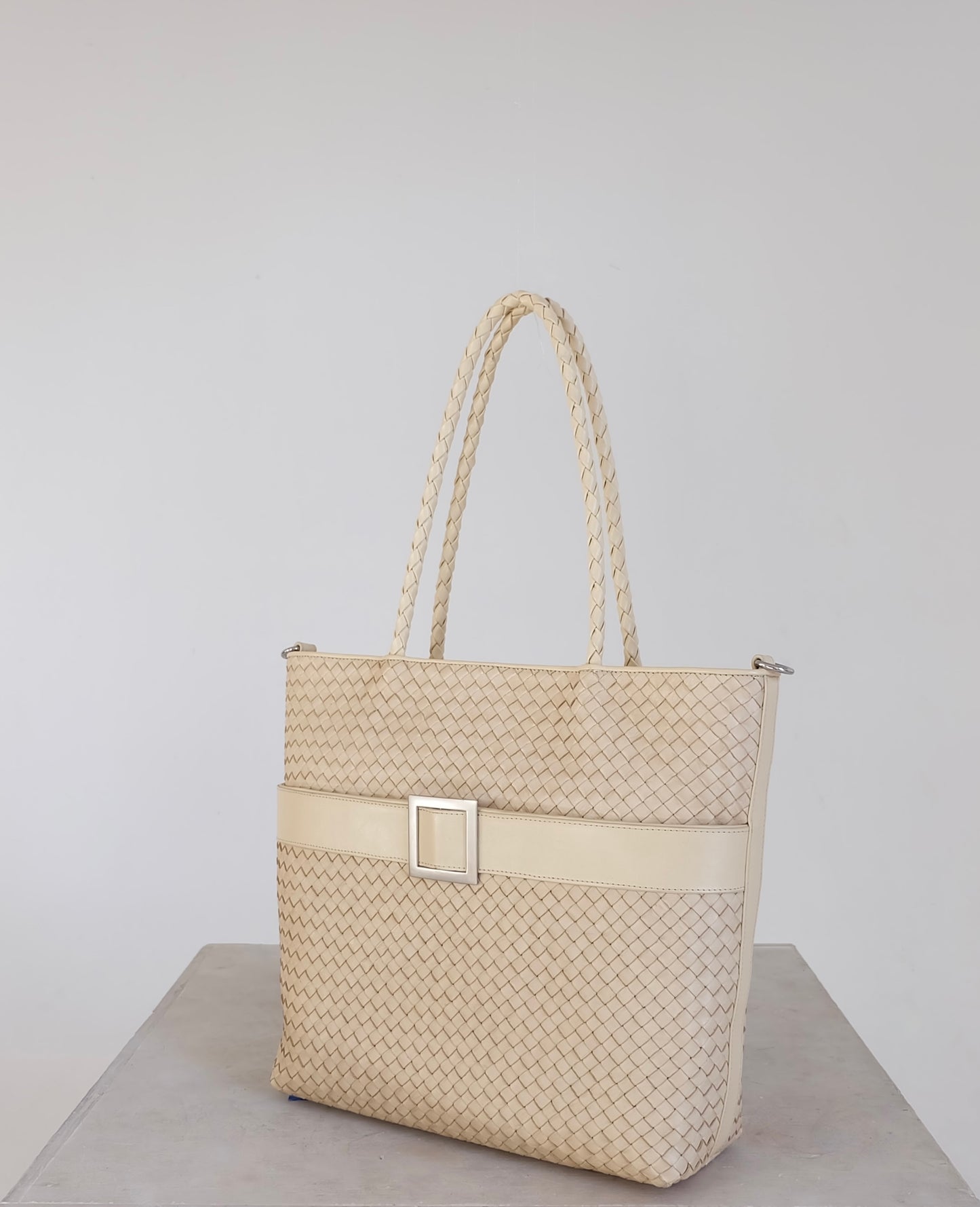 Sustainable Italian leather designer handbag, medium tote and crossbody in cream. Handbag with accent buckle that is a functional work of art.