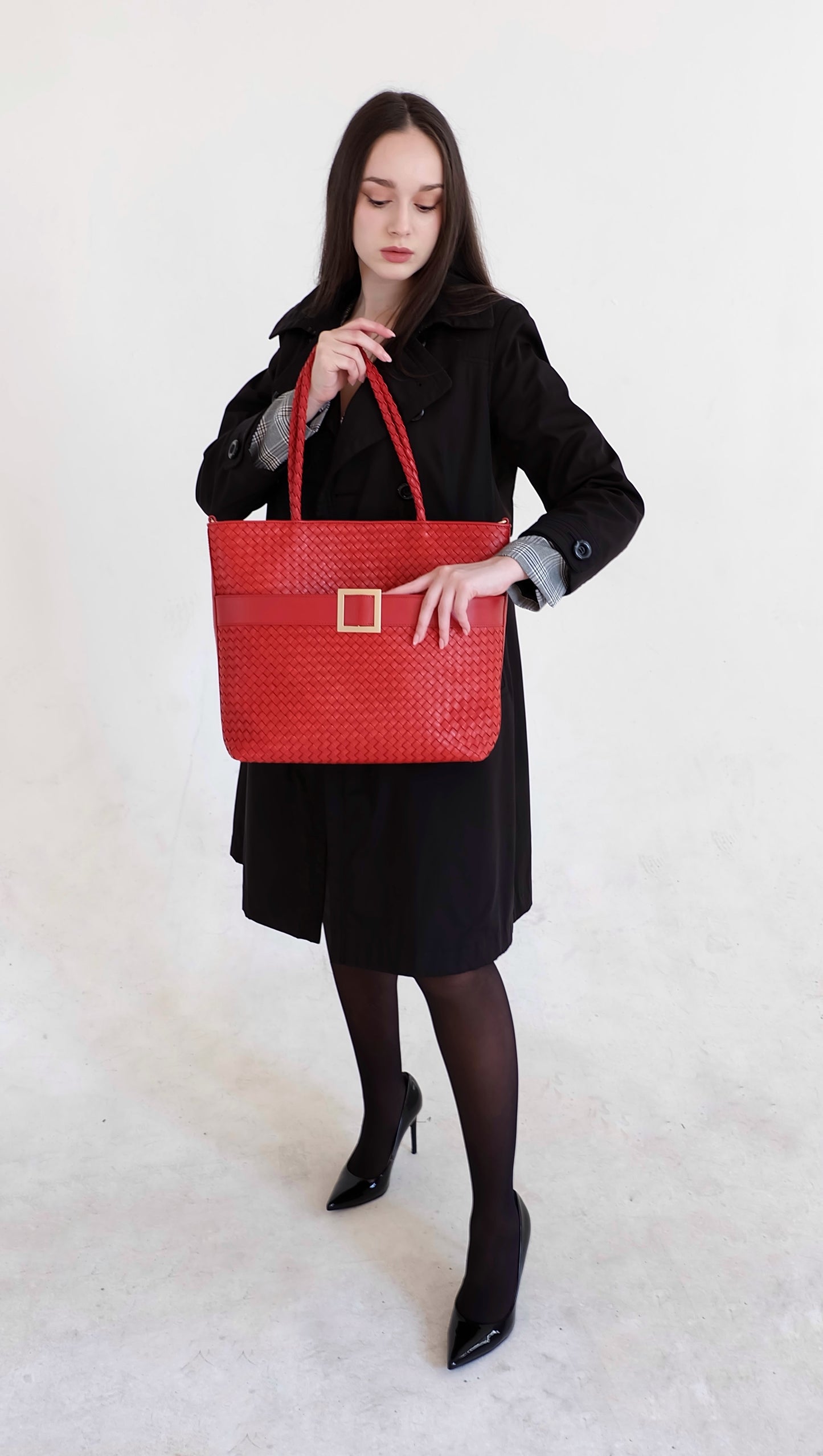 Beautiful, strong, independent, empowered and chic woman wearing a sustainable Italian leather designer handbag, medium tote and crossbody in chili red. Handbag with accent buckle that is a functional work of art.